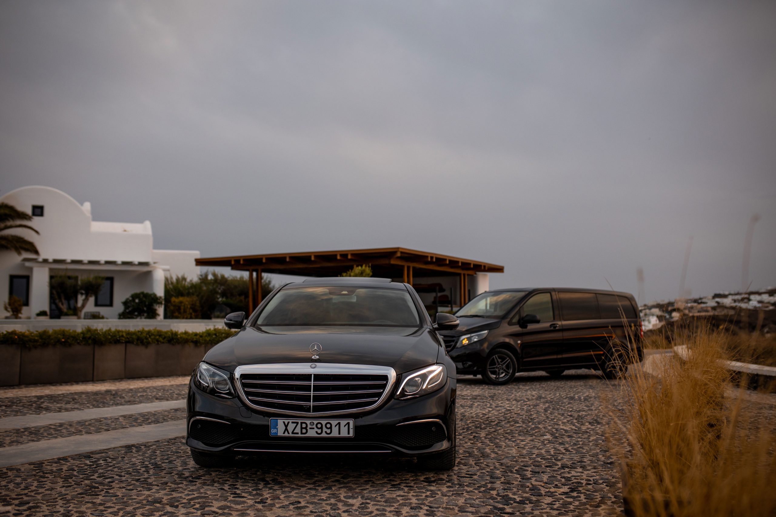 Mercedes-Benz E-Class and V-Class parked outside a whitewashed Santorini villa
